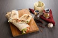 Shaurma chicken roll in a pita with fresh vegetables and cream sauce composition on wooden background Royalty Free Stock Photo