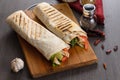 Shaurma chicken roll in a pita with fresh vegetables and cream sauce composition on wooden background Royalty Free Stock Photo