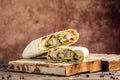 Shaurma, Kebab, pita, gyros wrap sandwich stuffed with sausages from chicken meat fresh vegetables and sauce on rustic wooden Royalty Free Stock Photo