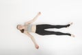 Shavasana. Corpse Pose. Yoga asanas. Young slender woman in sportswear lies on the white floor . Top view Royalty Free Stock Photo