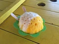 Maui shave ice on a table a yellow table with wooden spoons