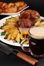 Shaved Montreal smoked meat served with potato wedges and pepper against the background of a glass beer.