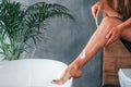 Shaves legs. Beautiful young woman have free time at home in the bath. Royalty Free Stock Photo