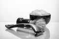 Shaving accessories. Glass table with reflections. White background