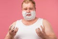 Shaving concept. Irritated man going to shave beard, holds sharp razor and brush