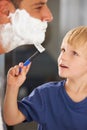 Shaving, father and son with cream, razor and smile on face, bonding in home and morning routine. Helping, learning and