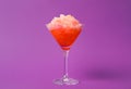 Shaving ice in martini glass on violet background