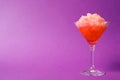 Shaving ice in martini glass on violet, space for text