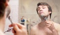 Shaving man reflected in the mirror Royalty Free Stock Photo