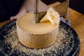Shaving tete de moine cheese using girolle knife. Monks head. Variety of Swiss semi-hard cheese made from cows milk