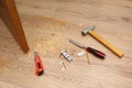 Shavings on floor from door latch installing. Wood sawdust from hole for door lock making. Hammer, chisel, knife, screws, pencil