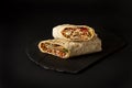 Shawarma, roll in lavash , grilled meat, with vegetables, sandwich , cut on a black background, horizontal, copy spase Royalty Free Stock Photo