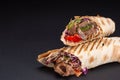 Shawarma sandwich - fresh roll of thin lavash or pita bread filled with grilled meat, mushrooms, cheese, cabbage, carrots, sauce,