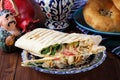 Shawarma in thin pita bread with chicken and vegetables on a plate