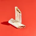 Shawarma wrap with beef on color background with hard shadow. Beef shawarma sandwich in abstract style. Simple fast food in