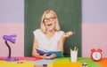 Shcool teacher in class on blackboard background. Professional portrait. Female student taking notes from a book at Royalty Free Stock Photo