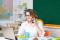 Shcool teacher with mobile phone use laptop in class on blackboard background. Professional portrait. Royalty Free Stock Photo