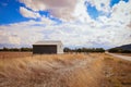 Shearing shed on country property surrounded by long dry grass under a cloudy sky in Central Victoria, Australia Royalty Free Stock Photo