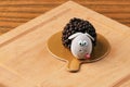 Sheep-shaped cake, pastries in a glaze, chocolate candy, brownie,on a wooden board