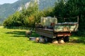 Sheep shelter from the sun and hide under a trailer in the shade