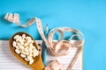 Sheet of Diet Plan and wooden spoon with a measuring tape on a blue background, diet, healthy lifestyle.