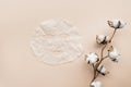 Sheet facial mask and cotton flower on beige paper background. Skin care, dermatology, beauty concept. Top view, flat lay, mockup