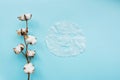 Sheet facial mask and cotton flower on pastel blue paper background. Skin care, dermatology, beauty concept. Top view, flat lay,