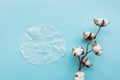 Sheet facial mask and cotton flower on pastel blue paper background. Skin care, dermatology, beauty concept. Top view, flat lay,