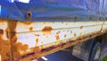 Sheet metal corrosion of old truck body. Rusty messy surface. Damaged grunge texture from road salt. Rust background. Protection c Royalty Free Stock Photo