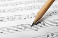 Sheet with music notes and pencil as background Royalty Free Stock Photo