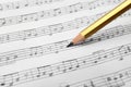 Sheet with music notes and pencil as background Royalty Free Stock Photo