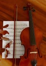 Sheet music and violin on wooden table. Top view classical musical instrument.