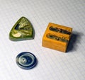 On a sheet of notebook pencil sharpener, a button and a stone amulet Royalty Free Stock Photo