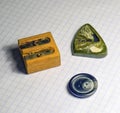 On a sheet of notebook pencil sharpener, a button and a stone am Royalty Free Stock Photo