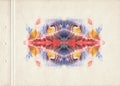 A sheet of old brown textured paper stained with symmetrical blue, red and orange color watercolor paint blot. Fine vintage grunge