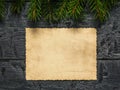 A sheet of old worn paper on a wooden background with fir branches. Form for wishes and greetings. Royalty Free Stock Photo