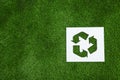 Sheet of paper with cutout recycling symbol on green grass, top view Royalty Free Stock Photo