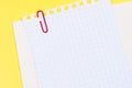 Sheet paper with paperclip on yellow background. Royalty Free Stock Photo