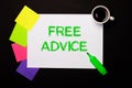 A sheet of paper with the words FREE ADVICE, a cup of coffee, bright multi-colored stickers for notes and a green marker on a Royalty Free Stock Photo