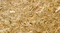 Sheet of plywood with fragments of compressed sawdust. Texture of yellow pressed wood shavings. Chipboard sheet close up,