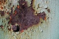 sheet of rusty metal with cracked and flaky paint, a metal surface with a bolt, abstract rusty metal texture with cracked green p Royalty Free Stock Photo