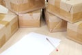 A sheet of white paper and a fountain pen on a background of sealed shipping boxes Royalty Free Stock Photo