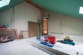 Sheets of drywall, parts of scaffolding, handle tools and construction material in the room of apartment during on the remodeling Royalty Free Stock Photo