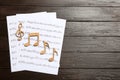 Sheets and music notes on wooden background Royalty Free Stock Photo