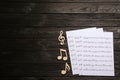 Sheets and music notes on wooden background, top view Royalty Free Stock Photo