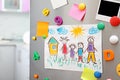 Sheets of paper, child`s drawing and magnets on refrigerator door in kitchen Royalty Free Stock Photo