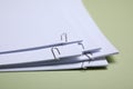 Sheets of paper with clips on light green background, closeup Royalty Free Stock Photo