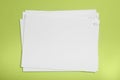 Sheets of paper with clips on light green background, top view Royalty Free Stock Photo
