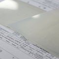Sheets of semi-transparent paper are placed over a printed document, revealing Royalty Free Stock Photo