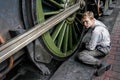 SHEFFIELD PARK, EAST SUSSEX/UK - SEPTEMBER 8 : Unidentified young Man cleaning a steam train wheel at Sheffield Park station East Royalty Free Stock Photo